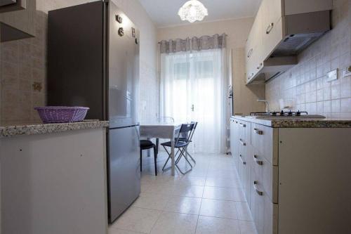 una cucina con tavolo e piano di lavoro di Alloggi Villa Sarsina ad Anzio