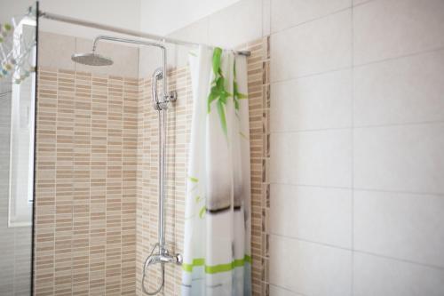 a shower with a shower curtain in a bathroom at Red Karmenita in Umag