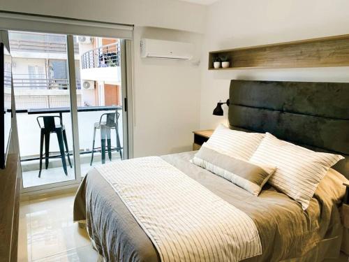 a bedroom with a large bed and a balcony at Santa Fe STAR -Cochera xa autos in San Miguel de Tucumán