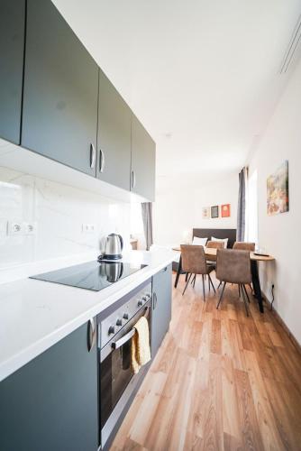 a kitchen with white cabinets and a wooden floor at Hotel Zur alten Stadtkellerei Leipzig in Leipzig
