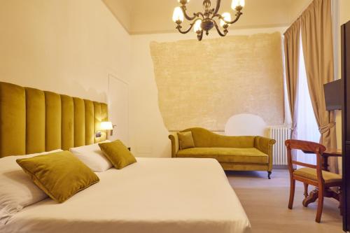 a bedroom with a bed and a chair and a chandelier at Residenza Maglioni al Battistero in Florence