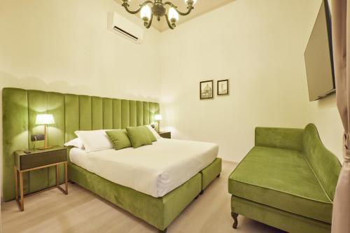 フィレンツェにあるResidenza Maglioni al Battisteroのベッドルーム(大型ベッド1台、緑のベンチ付)