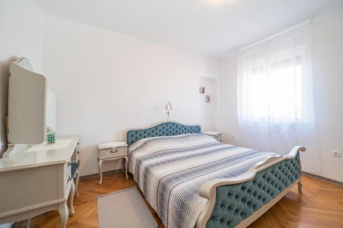 a bedroom with a bed and a dresser and a mirror at Red Karmenita in Umag