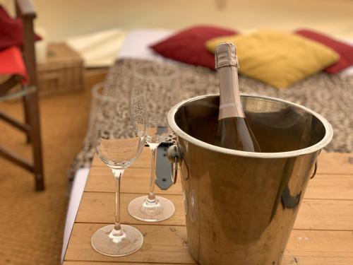 a bucket with a bottle of wine and two wine glasses at Home Farm Radnage Glamping Bell Tent 2, with Log Burner and Fire Pit in Radnage