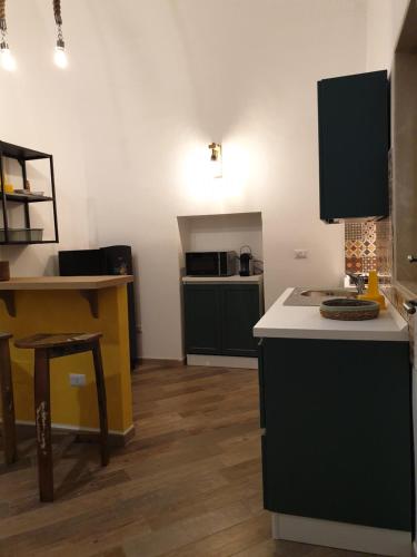 a kitchen with green cabinets and a counter top at La Casetta di Zoe Apartment in Molfetta