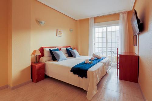 a bedroom with a large bed and a television at Hotel Tuto in Torrevieja