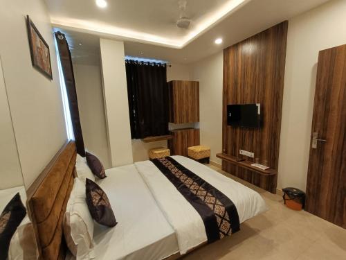 - une chambre avec un lit et une télévision dans l'établissement Hotel Vrinda Inn, à Udaipur