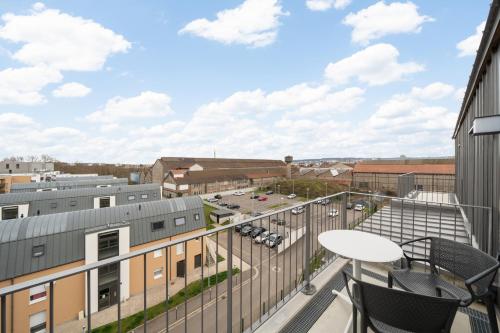 a balcony with a table and chairs on a building at Domitys La Cristal'In in Nancy
