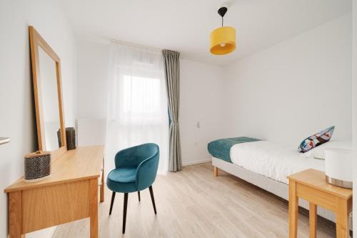 a bedroom with a bed and a desk and a chair at Domitys La Cristal'In in Nancy