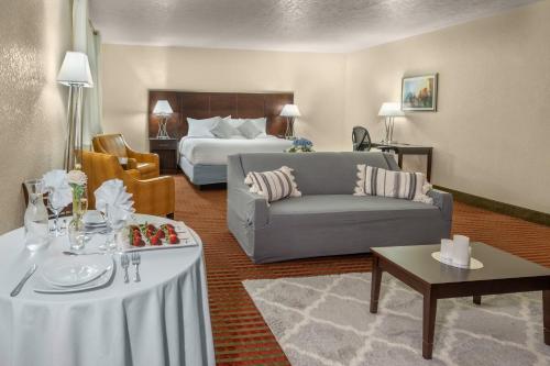 Pokój hotelowy z łóżkiem, kanapą i stołem w obiekcie Grand Williston Hotel and Conference Center w mieście Williston
