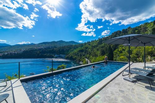 una piscina con vista sul lago e sulle montagne di Mare Sano apartment #5 a Opatija