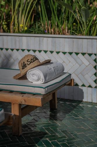 a bench with a towel and a hat on it at Riad Le Saadien ,Adult only in Marrakech