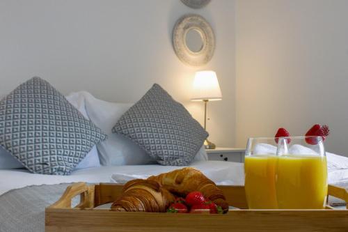 taca z rogalikami i sokiem pomarańczowym na łóżku w obiekcie Walton by Pay As U Stay w mieście Milton Keynes
