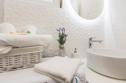 een witte badkamer met een wastafel en handdoeken op een aanrecht bij Apartments Marina in Bibinje
