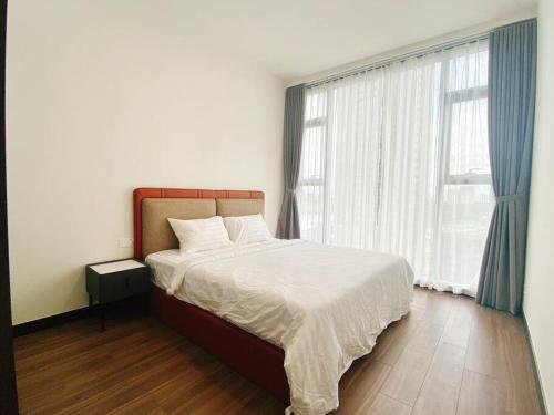 a bedroom with a bed and a large window at Morden 2brs apartment at Empire City in Ho Chi Minh City