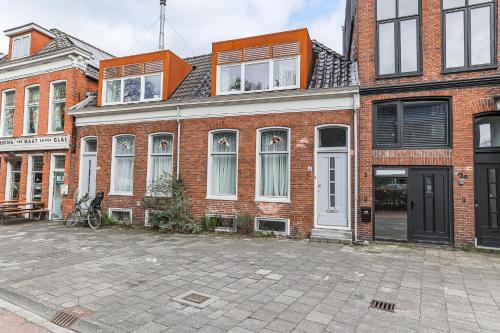 a large brick building with white doors and windows at Cozy Typical Dutch Apartments in Groningen