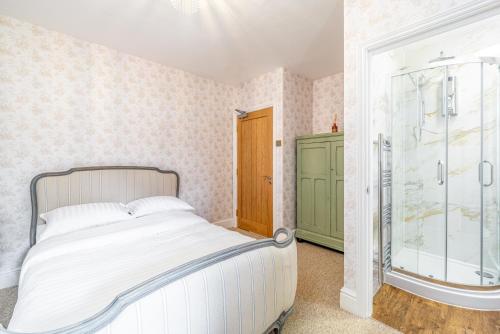 um quarto com uma cama e uma cabina de duche em vidro em The Whichcote Arms 