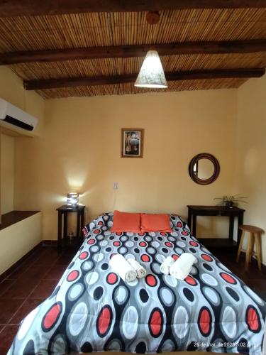 a bedroom with a large bed with red pillows at La Casa de la Abuela Tilcara in Tilcara