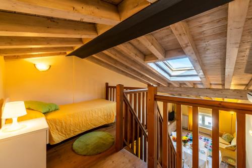 een slaapkamer met een bed in een kamer met houten plafonds bij Flowers Apartments in Desenzano del Garda