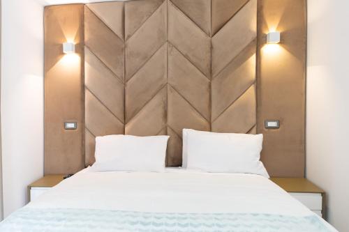 a bedroom with a large white bed with two pillows at 23Apartments in La Spezia