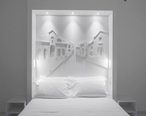 a bed in a room with a picture of houses at Vittorio Veneto Matera Luxury Rooms in Matera