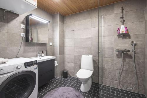 La salle de bains est pourvue d'un lave-linge et de toilettes. dans l'établissement Ydinkeskustassa saunallinen loft huoneisto, à Kuopio