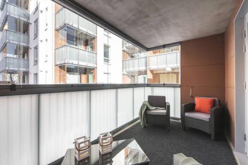 a balcony of a building with chairs and a table at Ydinkeskustassa saunallinen huoneisto kahdessa tasossa in Kuopio