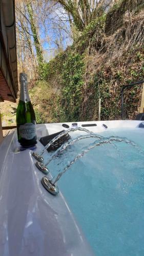 a bottle of wine sitting on top of a hot tub at La cabane d'Achille - La Roche-en-Ardenne in La Roche-en-Ardenne