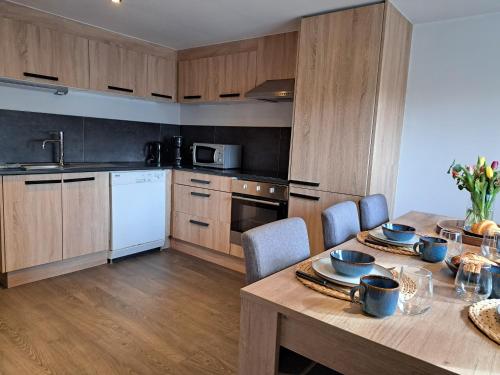 a kitchen with a wooden table with chairs and a dining room at La cabane d'Achille - La Roche-en-Ardenne in La Roche-en-Ardenne