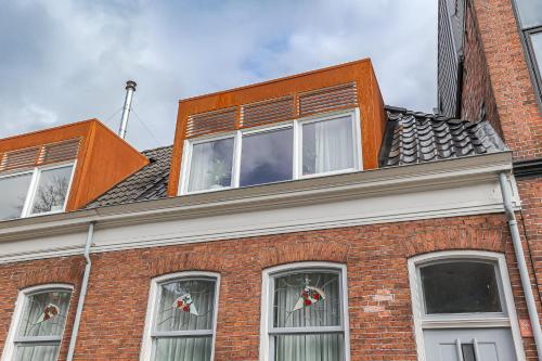 a red brick building with windows on top of it at Cozy Typical Dutch Apartments in Groningen
