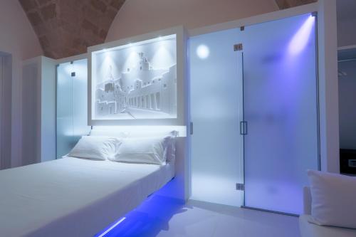 マテーラにあるVittorio Veneto Matera Luxury Roomsのベッドルーム1室(壁に絵が描かれた白いベッド1台付)