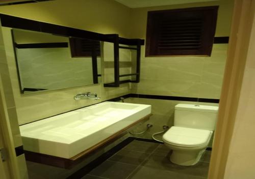 a bathroom with a white sink and a toilet at CEYLON VILLA NILAVELI in Trincomalee