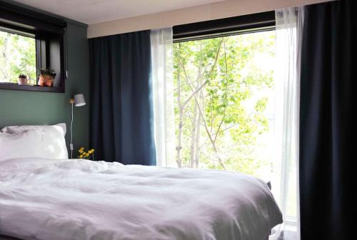 a bedroom with a white bed and a large window at Villa Hegge - Design Cabin with fab view in Sjøvegan