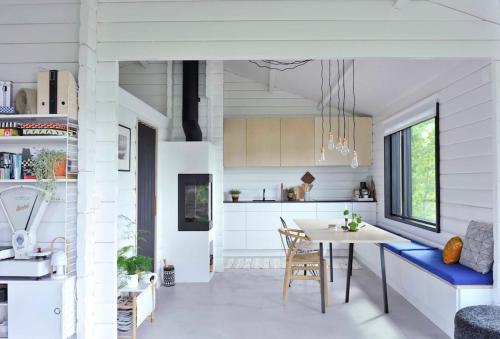 a kitchen and dining room with a table and chairs at Villa Hegge - Design Cabin with fab view in Sjøvegan