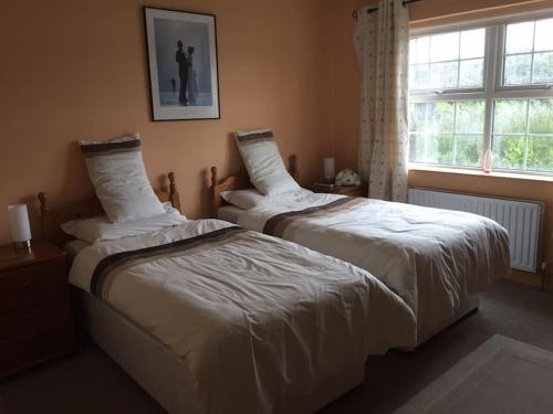 2 camas en un dormitorio con ventana en Fermanagh lakeside Self Catering, en Corranny