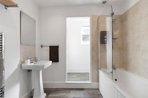 a white bathroom with a sink and a shower at Church View II by Staytor Accommodation in Exeter