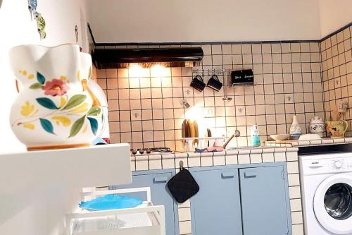 een keuken met een wastafel en een wasmachine bij Al Capo in Acireale