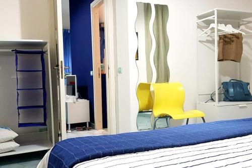 - une chambre avec un lit et deux chaises jaunes dans l'établissement Al Capo, à Acireale