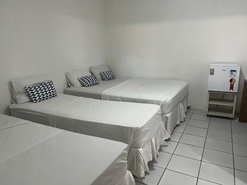 two beds and a couch in a room at Jampa Mar Pousada in João Pessoa