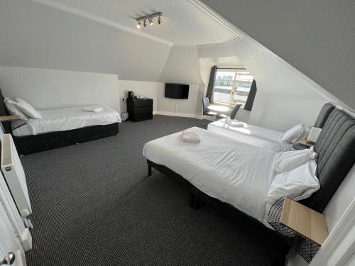 a hotel room with two beds and a window at Lost Guest House Aberdeen in Aberdeen