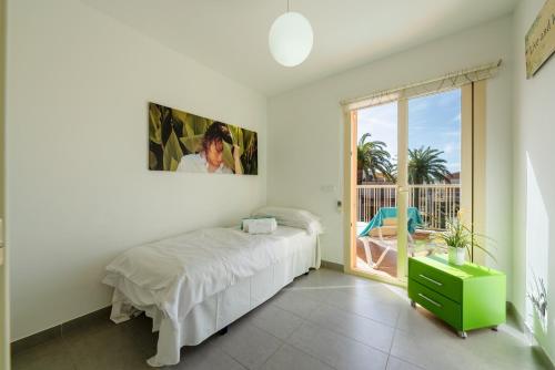 a white bedroom with a bed and a balcony at M4R Casa Iuca in Alcudia