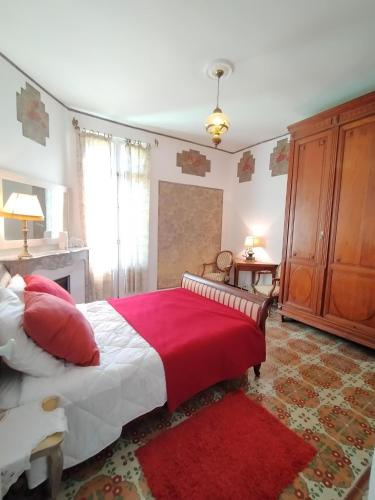 une chambre avec un grand lit avec une couverture rouge dans l'établissement Mas des Marbres Sauvages dans un parc immense à 10mn de la plage, à Sainte-Marie-la-Mer