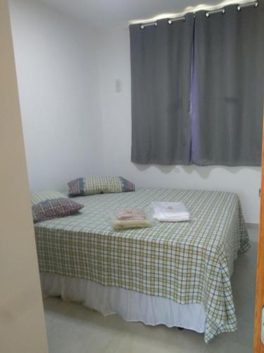 1 dormitorio con 1 cama con manta a cuadros y ventana en Cs6 Casa de 3 Quartos a 15min de Curitiba, en Campina Grande do Sul
