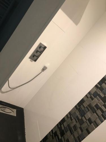 a room with a white ceiling with a hose on it at Neptune in Cavalaire-sur-Mer