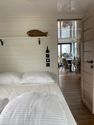 a bedroom with a white bed and a dining room at SeaYou House boat in Offingawier