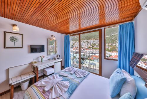 a bedroom with a bed and a desk and window at Hotel Sonne - Adults Only in Kas