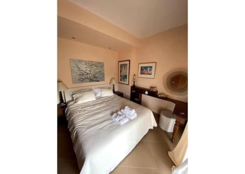 a bedroom with a large white bed and a desk at Υπέροχο Διαμέρισμα στους καταρράκτες της Έδεσσας in Edessa