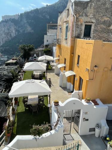 un balcón con mesas y sombrillas en un edificio en Villa Amalfi, en Amalfi