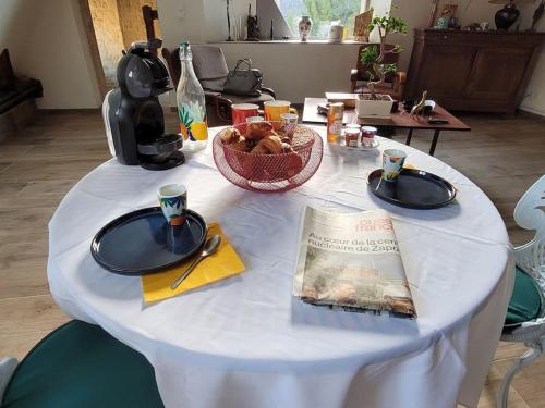 une table blanche avec des assiettes de nourriture dans l'établissement LA MAITRISE, à Bayeux