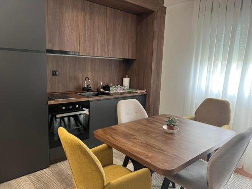uma cozinha com uma mesa de madeira e cadeiras amarelas em Kuman Apartments em Kumanovo